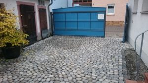 Pflasterarbeiten und blaues Tor